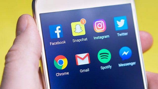Telefoon met pictogrammen van verschillende socialmediakanalen zoals facebook, instagram en twitter